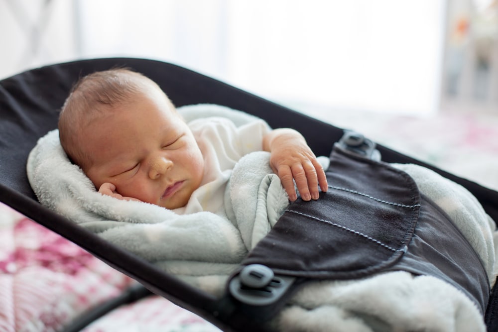 A baby sleeping in a swing