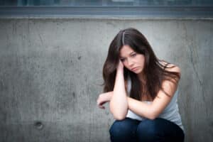A victim of hazing injuries sitting alone outside