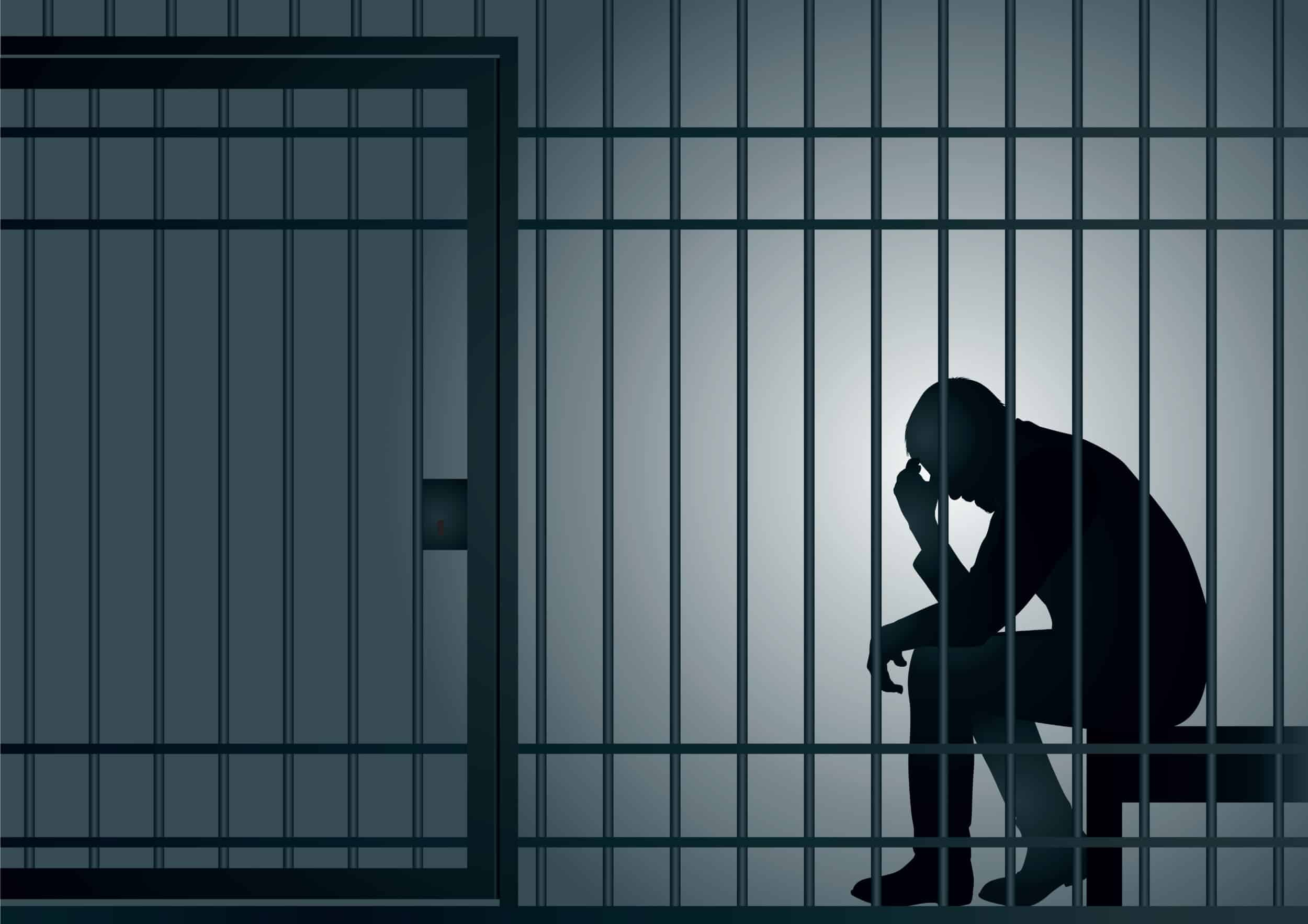 A wrongfully incarcerated man sitting behind bars