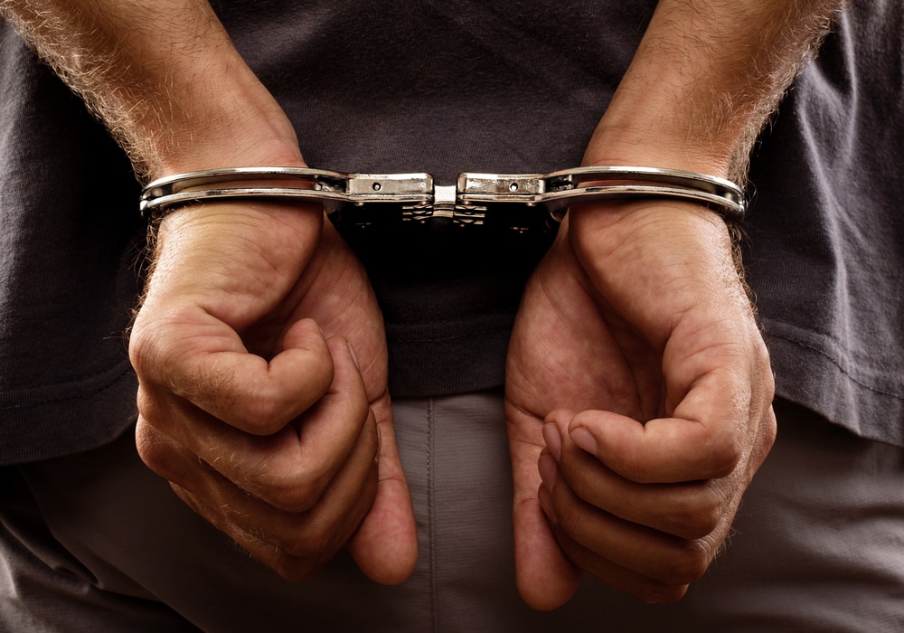 A close-up shot of handcuffs on a wrongfully incarcerated man’s wrists