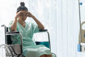 A victim of delayed diagnosis sitting in a wheelchair in a hospital