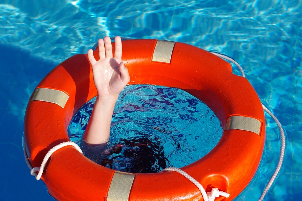 A life buoy with a drowning victim's hand reach out of it