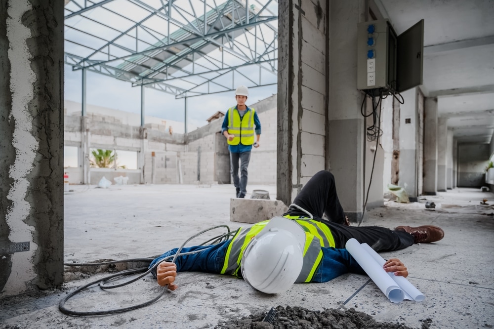 A worker lying on the ground after an electric shock accident