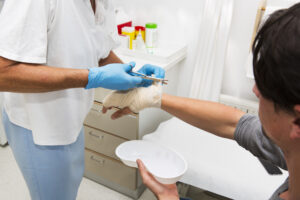 A doctor bandaging a patient's hand after a pressure cooker accident