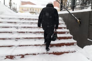 A man walking up snow-covered stairs