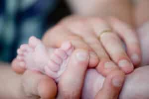 A parent holding a baby's feet