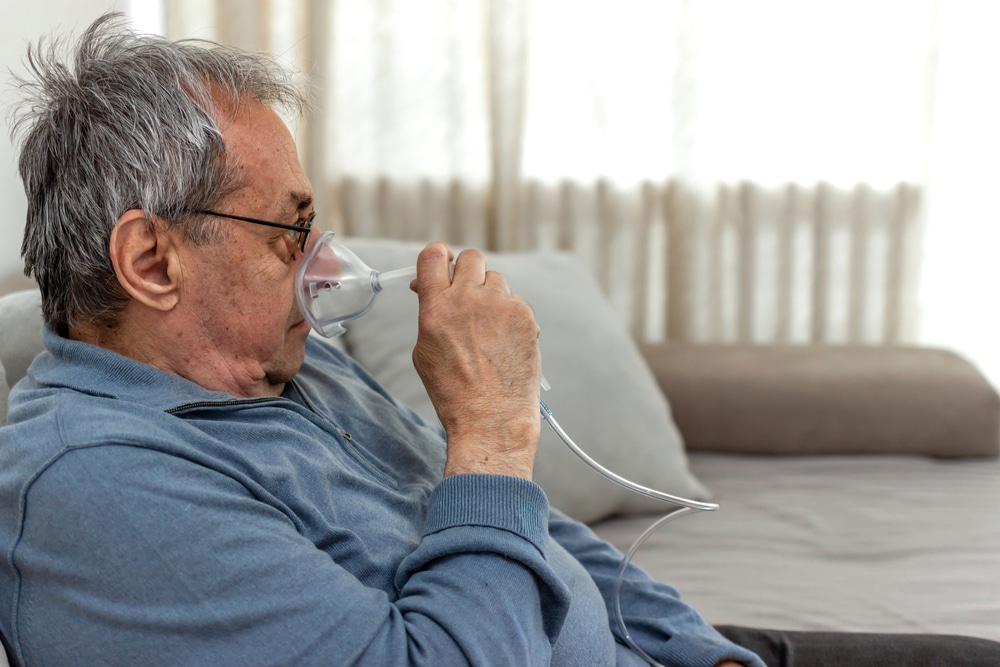 A man with Legionnaires' disease using an oxygen mask to breathe