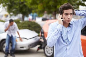 A man talking on the phone after an Uber accident