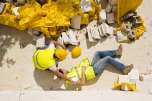 A construction worker lying on the ground after a fall at work